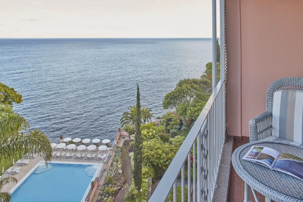 Balcón con vistas a la piscina y al mar desde una habitación de Reid's Palace