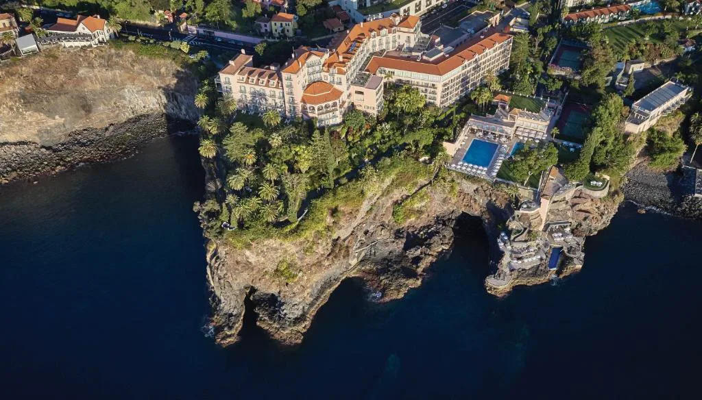 Vista aérea de Reid's Palace sobre el acantilado de São Martinho, con sus piscinas y jardines frente al Atlántico, Funchal