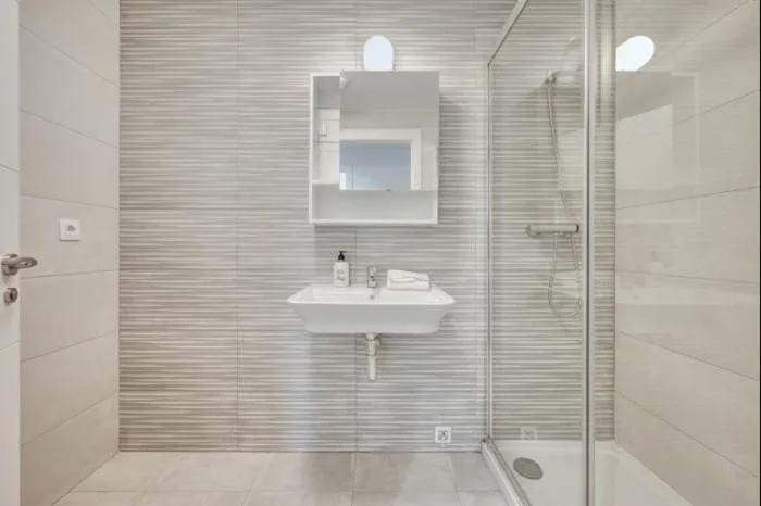 Baño con ducha y mampara de cristal