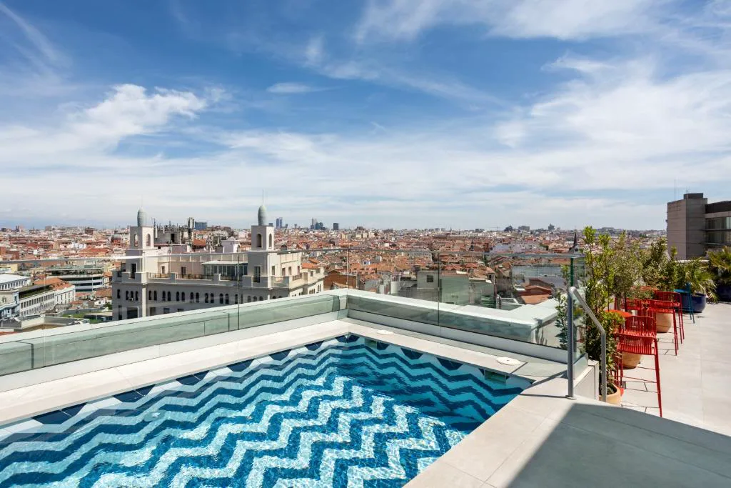 Piscina en la azotea con cristal y edificios de la Gran Vía al fondo