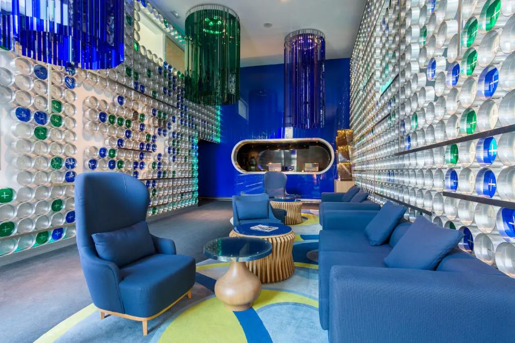 Salón con sillones azules y paredes de vidrio de colores