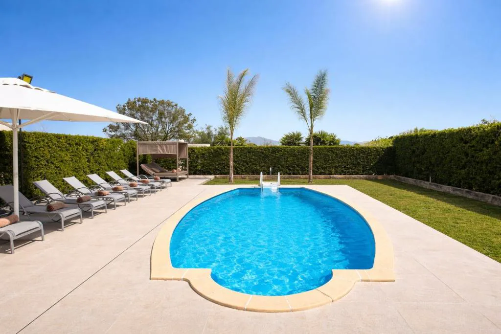 Piscina con tumbonas y cenador junto a setos verdes, Sa Figuera Roja