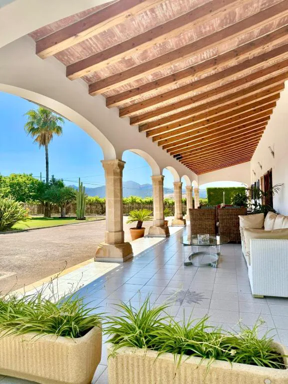 Terraza porticada con arcos de piedra y vistas a las montañas y viñedos, Sa Figuera Roja