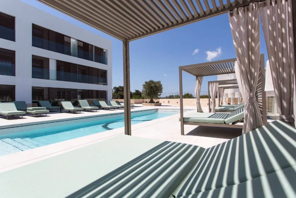 Camas balinesas con dosel y cortinas junto a la piscina, Sa Pedrera Suites & Spa