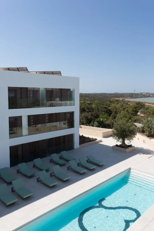 Bañera de hidromasaje en terraza cubierta con planta tropical y sillón de mimbre, Sa Pedrera Suites & Spa, Es Pujols, Formentera