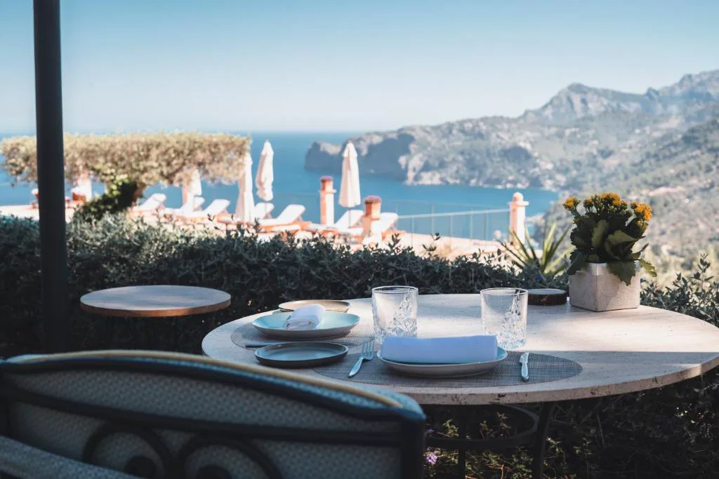 Mesa dispuesta para comer con vistas al mar y los acantilados de la Serra de Tramuntana, Sa Pedrissa
