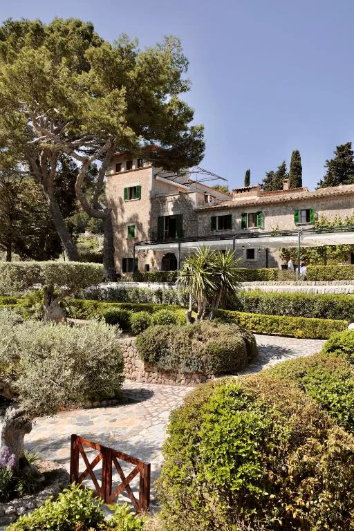 Jardín con setos recortados y la fachada de piedra de la finca del siglo XVI, Sa Pedrissa