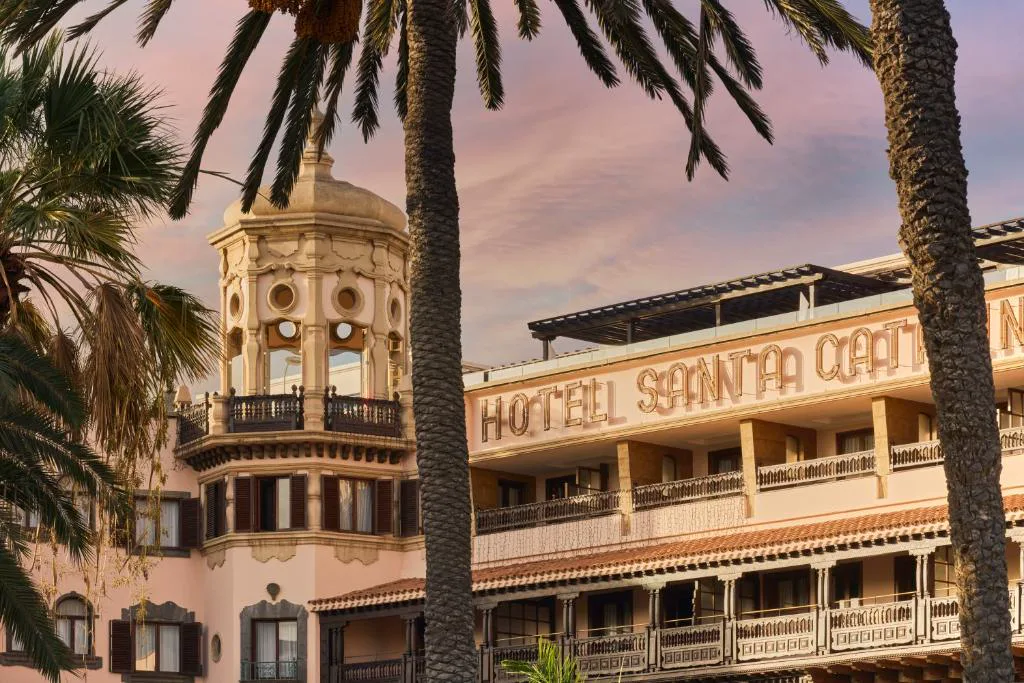 Fachada del hotel al atardecer con la torre mirador y el rótulo Hotel Santa Catalina