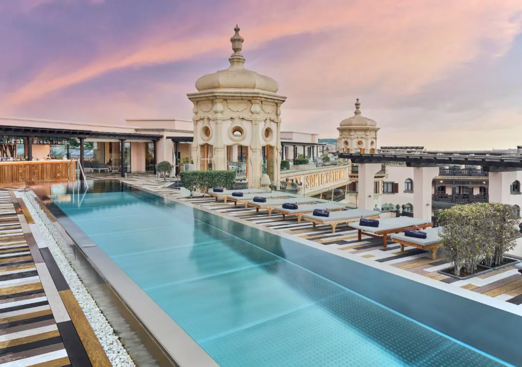 Piscina en la azotea con torres ornamentales al atardecer, Hotel Santa Catalina