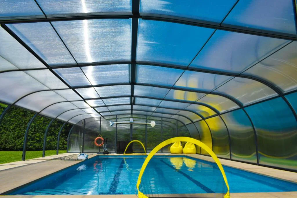 Piscina cubierta con techo de cristal en una urbanización