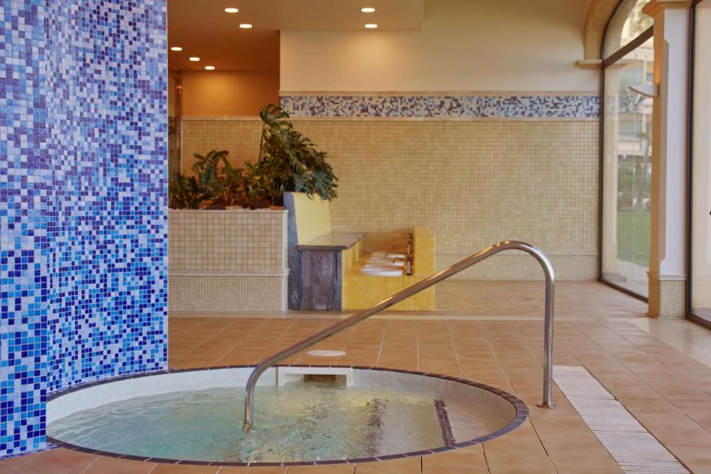 Jacuzzi circular de mosaico azul en el Secrets Spa, Secrets Bahía Real