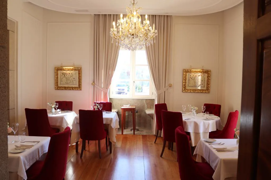 Comedor del restaurante con lámpara de araña y sillas de terciopelo rojo, Solar do Requeijo