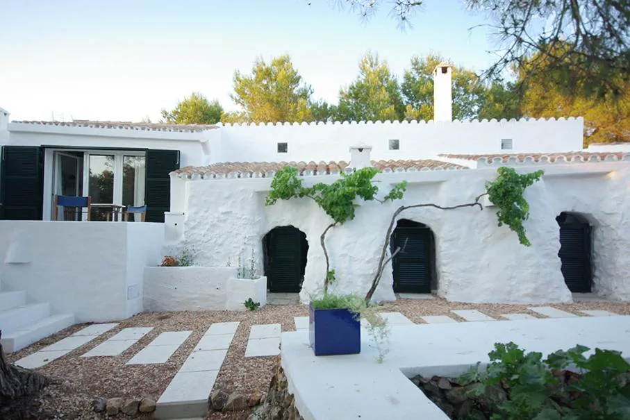 Fachada encalada con arcos y cuevas-almacén tradicionales de S'Olivera, casa de campo en Alaior, Menorca
