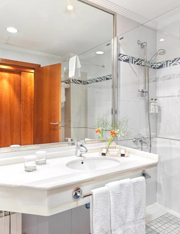 Baño con ducha de cristal y detalles en madera, Hotel Spa Galatea