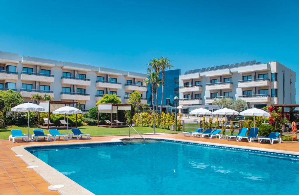 Piscina exterior con tumbonas azules y jardín, Hotel Spa Galatea