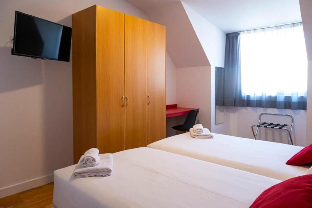 Habitación con armario de madera y toallas dobladas sobre la cama, Spa Suites Odeón