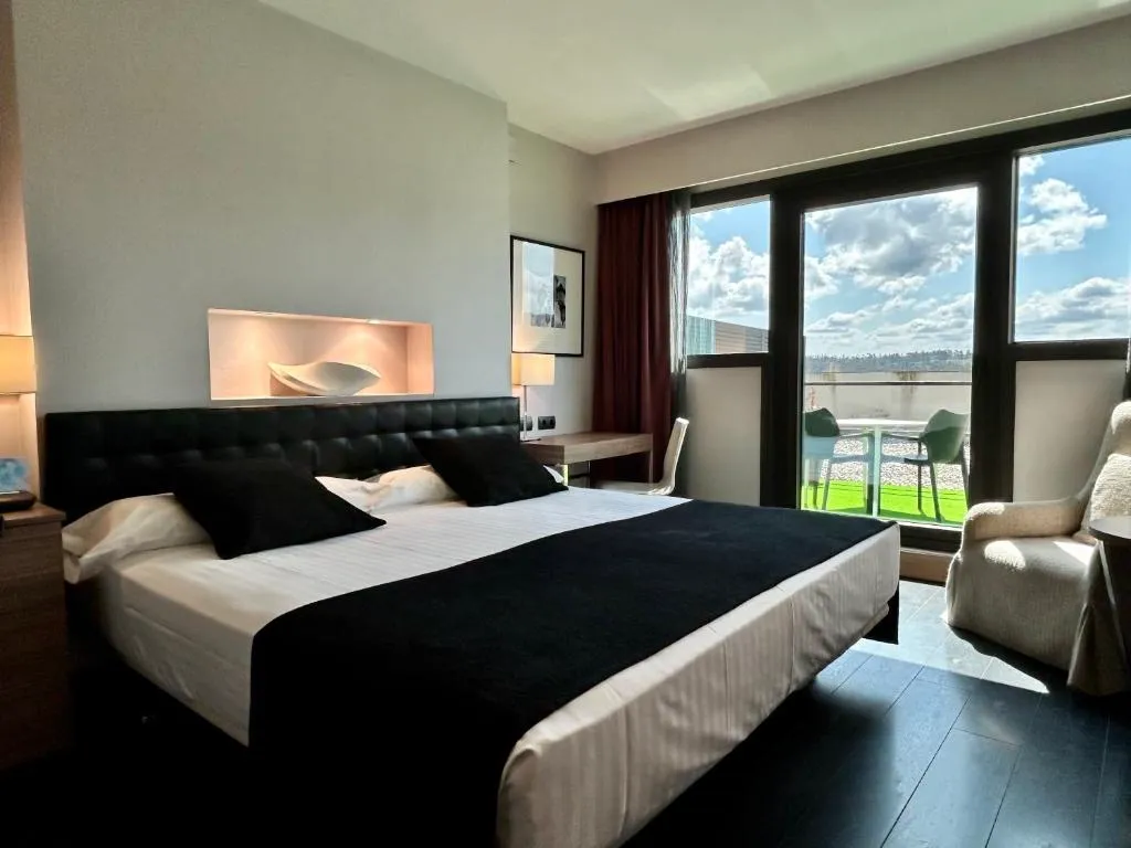 Habitación con cabecero negro capitoné y terraza con vistas