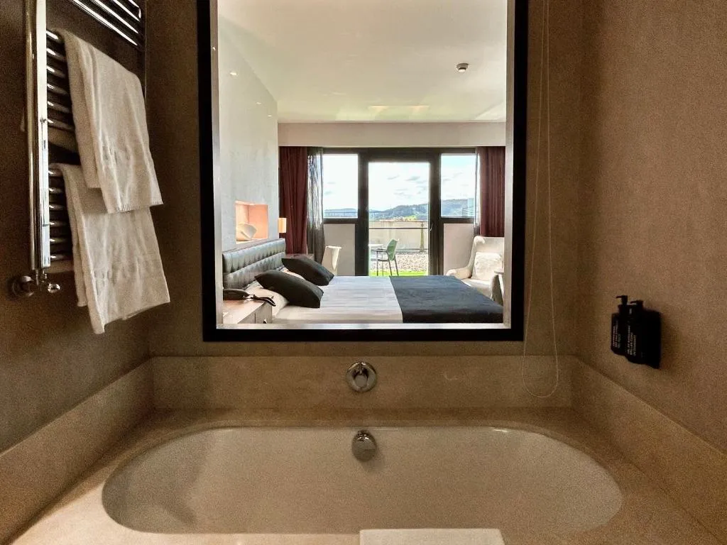 Baño de la suite con bañera y vista enmarcada al dormitorio