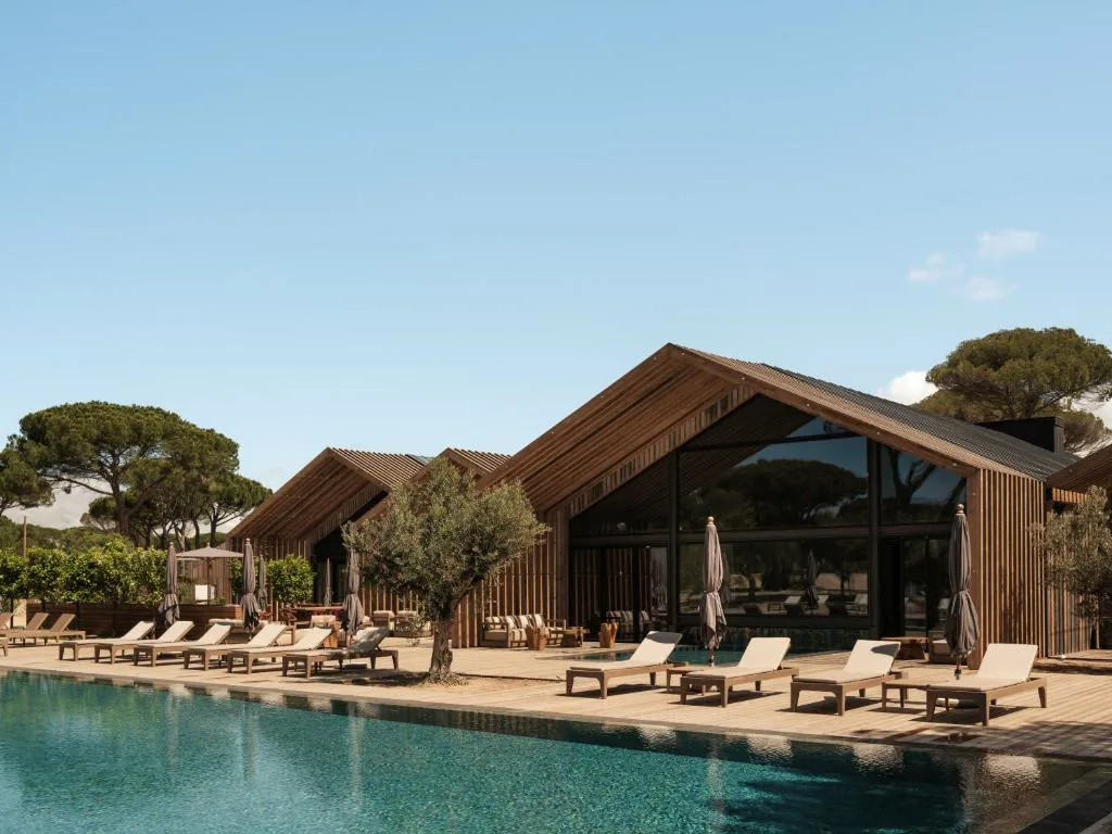 Piscina de Sublime Comporta junto a las villas de madera entre pinos, Alentejo litoral