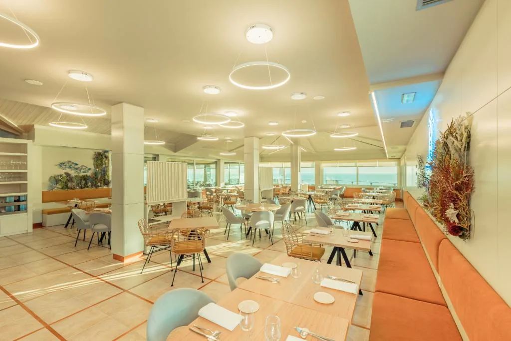 Restaurante luminoso con vistas al mar y mesas vestidas, Talaso Atlántico