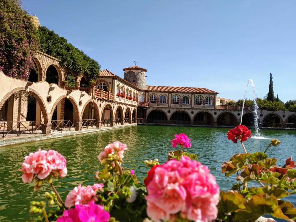 Lago con arcos del antiguo balneario y flores