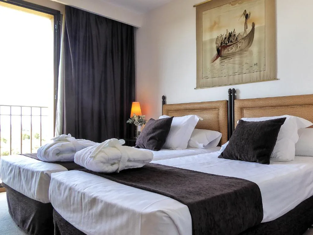 Habitación con cama doble y albornoces