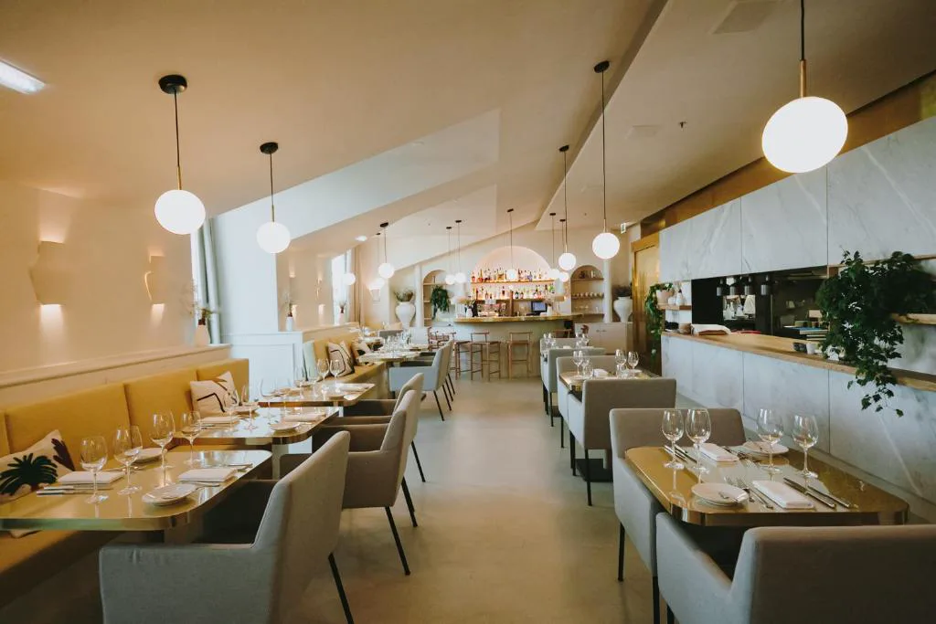 Restaurante de The Lumiares con barra de mármol y mesas de latón