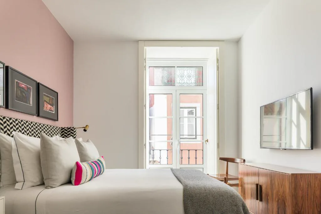 Habitación en tonos rosa empolvado con balcón de hierro forjado, The Lumiares