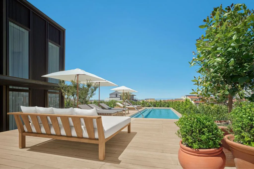 Terraza de azotea con sillones y piscina al fondo