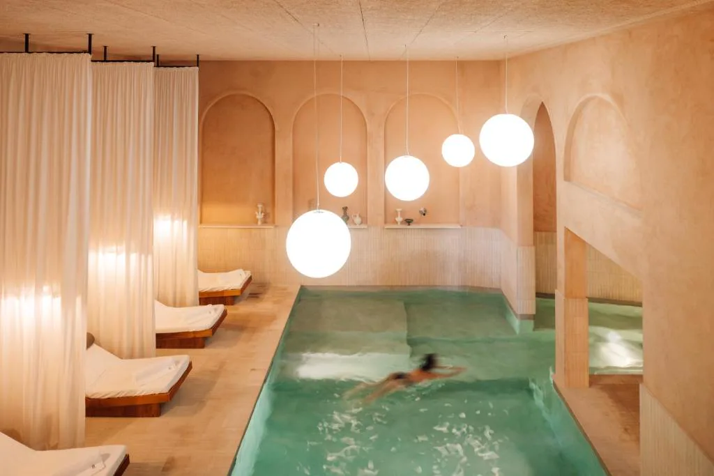Piscina cubierta del spa de The Rebello, con arcos en tonos terracota
