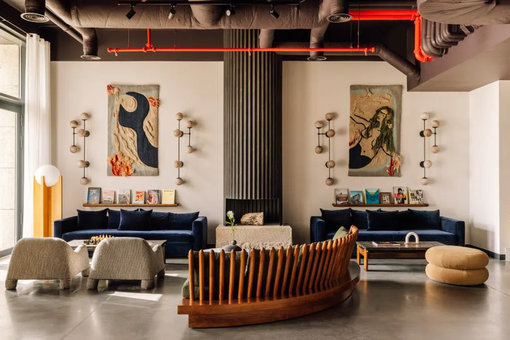 Salón de The Rebello con sofás azules y tapices de inspiración marina