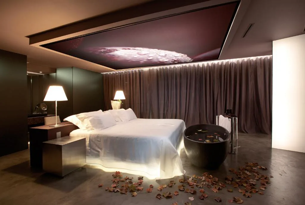 Suite en tonos oscuros con bañera japonesa y hojas de vid decorativas, The Vine Hotel