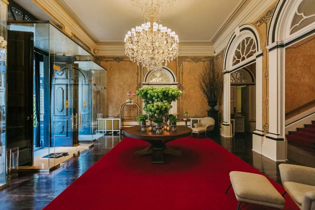 Vestíbulo de entrada con alfombra roja y araña de cristal, Torel Palace Porto