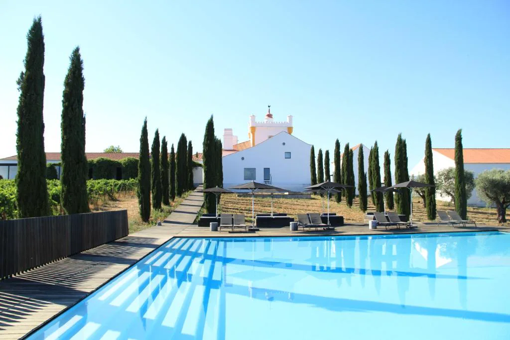 Piscina exterior flanqueada por cipreses junto a la herdade, Torre de Palma Wine Hotel