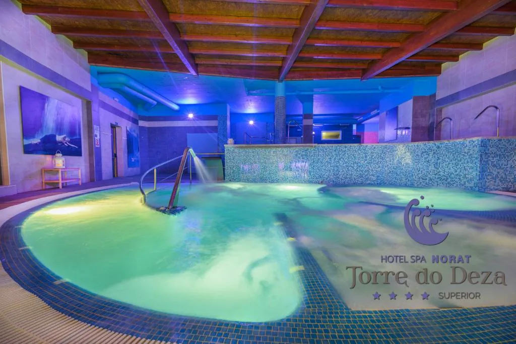 Piscina de hidromasaje circular con iluminación verde y techo de madera, Hotel Spa Norat Torre do Deza