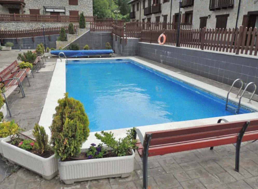 Piscina rectangular entre casas de piedra