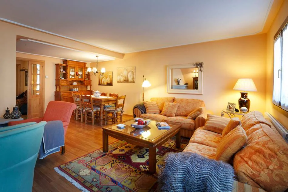 Salón con sofás de colores y mesa de madera