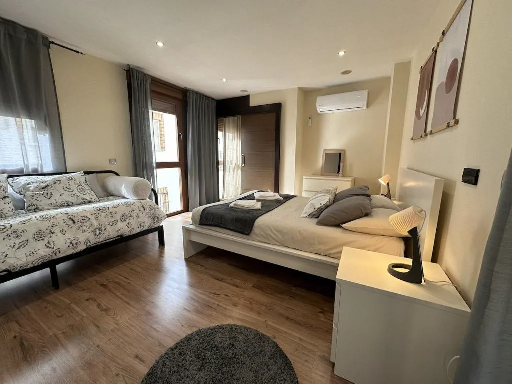 Dormitorio con cama doble y cabecero claro