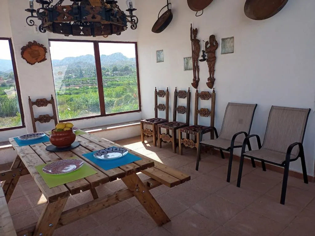 Terraza con mesa y sillas bajo una pérgola