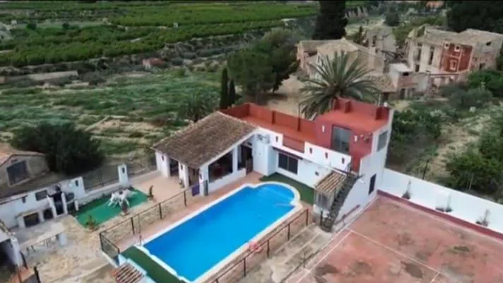Vista aérea de la casa con piscina y huerta
