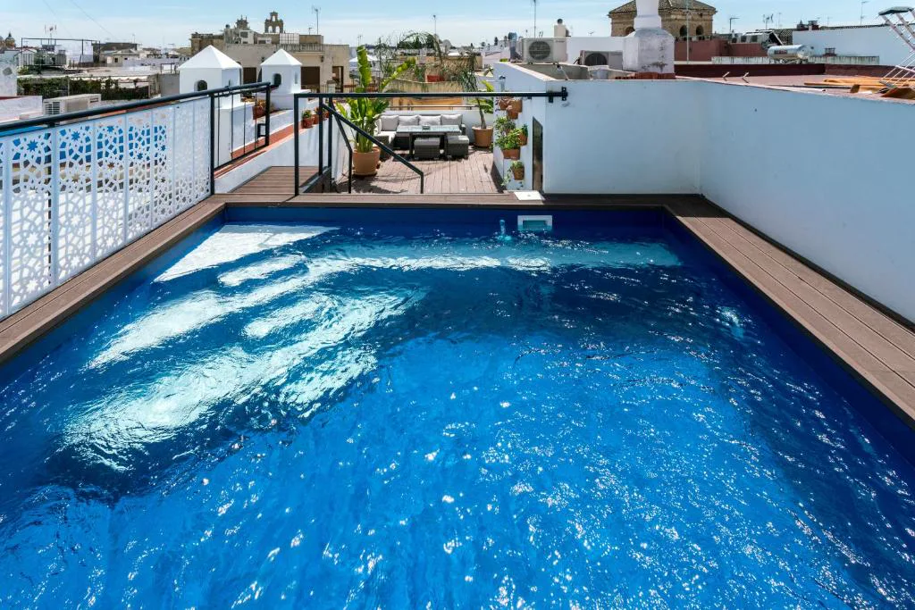 Piscina en la azotea con celosía blanca y vistas a la ciudad