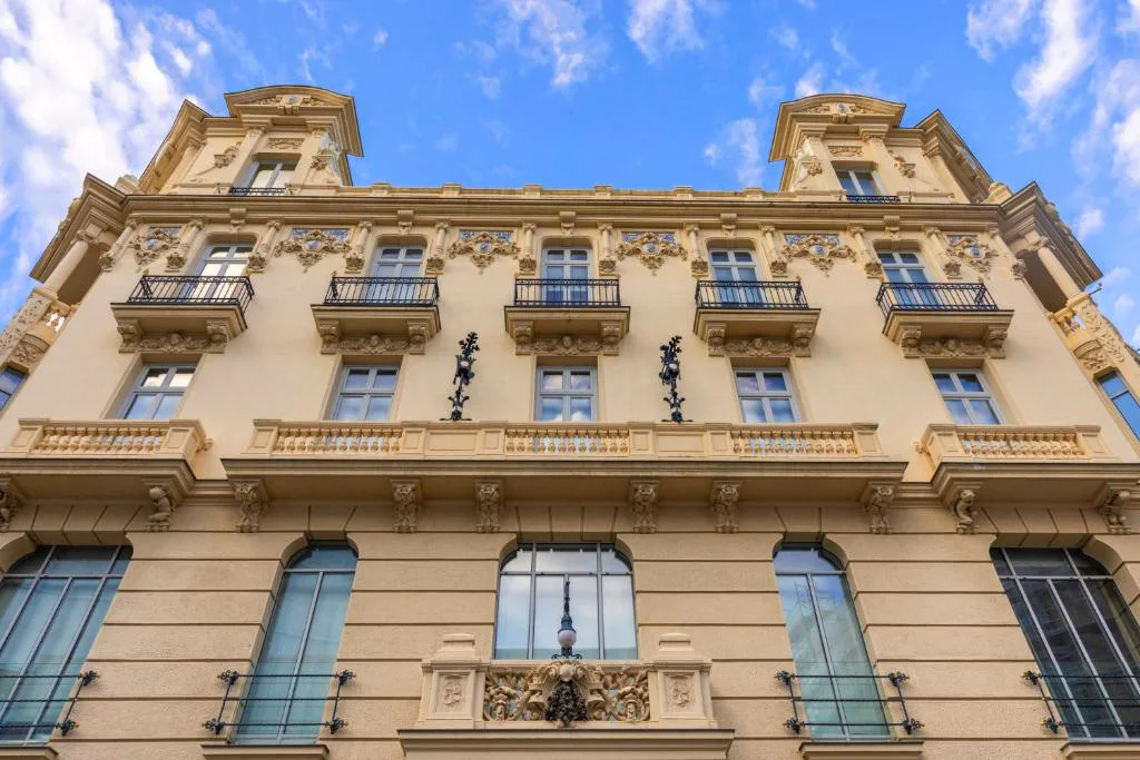 Fachada de piedra con balcones de hierro del palacio que ocupa el URSO Hotel & Spa