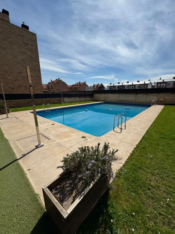 Piscina azul entre bloques de viviendas y césped