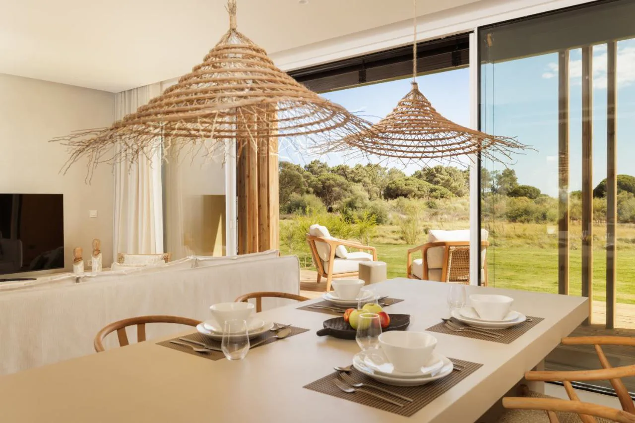Comedor con lámparas de mimbre y vistas al jardín en Verdelago Resort