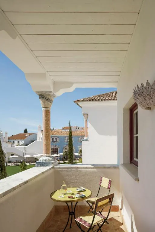 Balcón privado con mesa de desayuno y vistas al pueblo de Melides