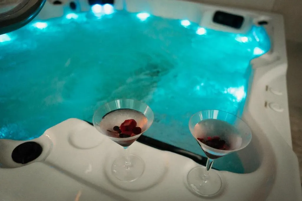 Jacuzzi de la zona wellness privada del Via Aetcal Hotel & Wellness, con dos copas junto al agua para una escapada en pareja
