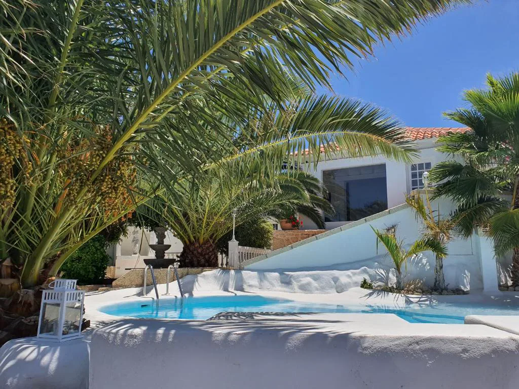 Jacuzzi circular con fuente de piedra frente a la fachada de la villa, Villa Adriano