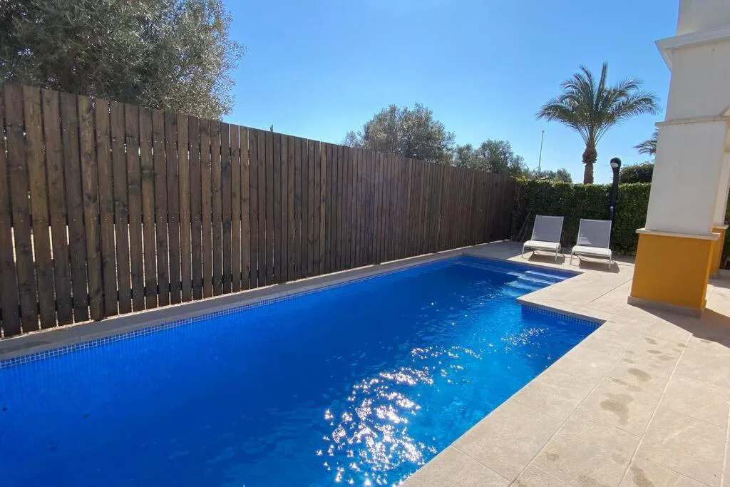 Piscina alargada con tumbonas