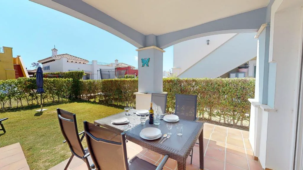 Terraza con mesa y vistas al jardín