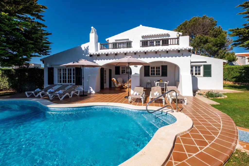 Villa blanca tradicional menorquina con piscina y tumbonas, Villa Binigo, en Binibeca, Menorca